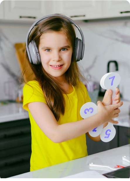 Young girl wearing headphones and holding up numbers